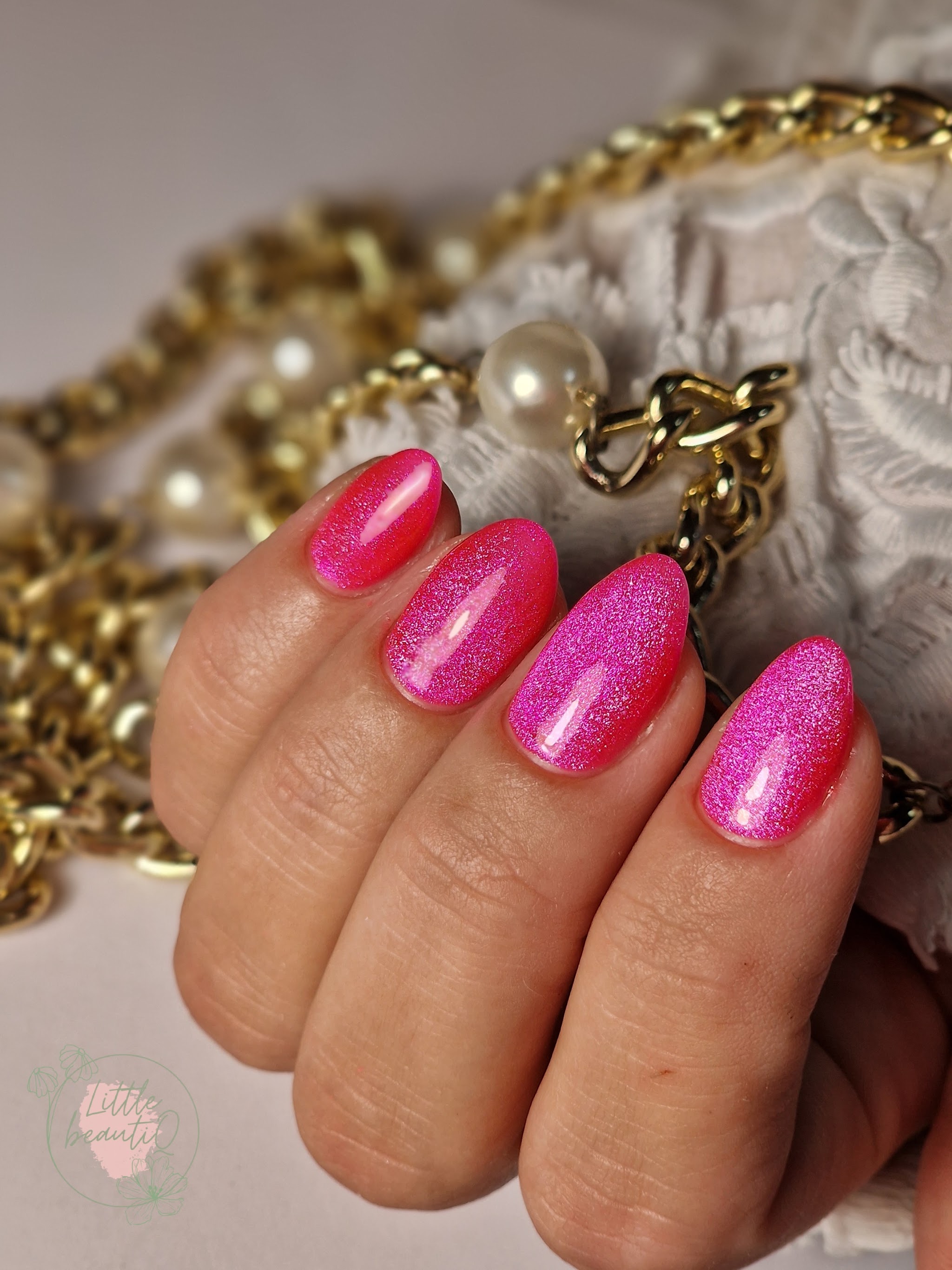 Felroze glitternagels met gouden ketting